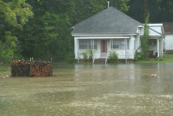 Flooded residential street in Indiana with rescue boat navigating high water.
