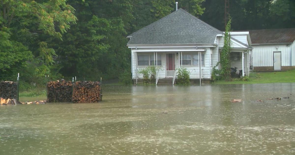 Flooded residential street in Indiana with rescue boat navigating high water.